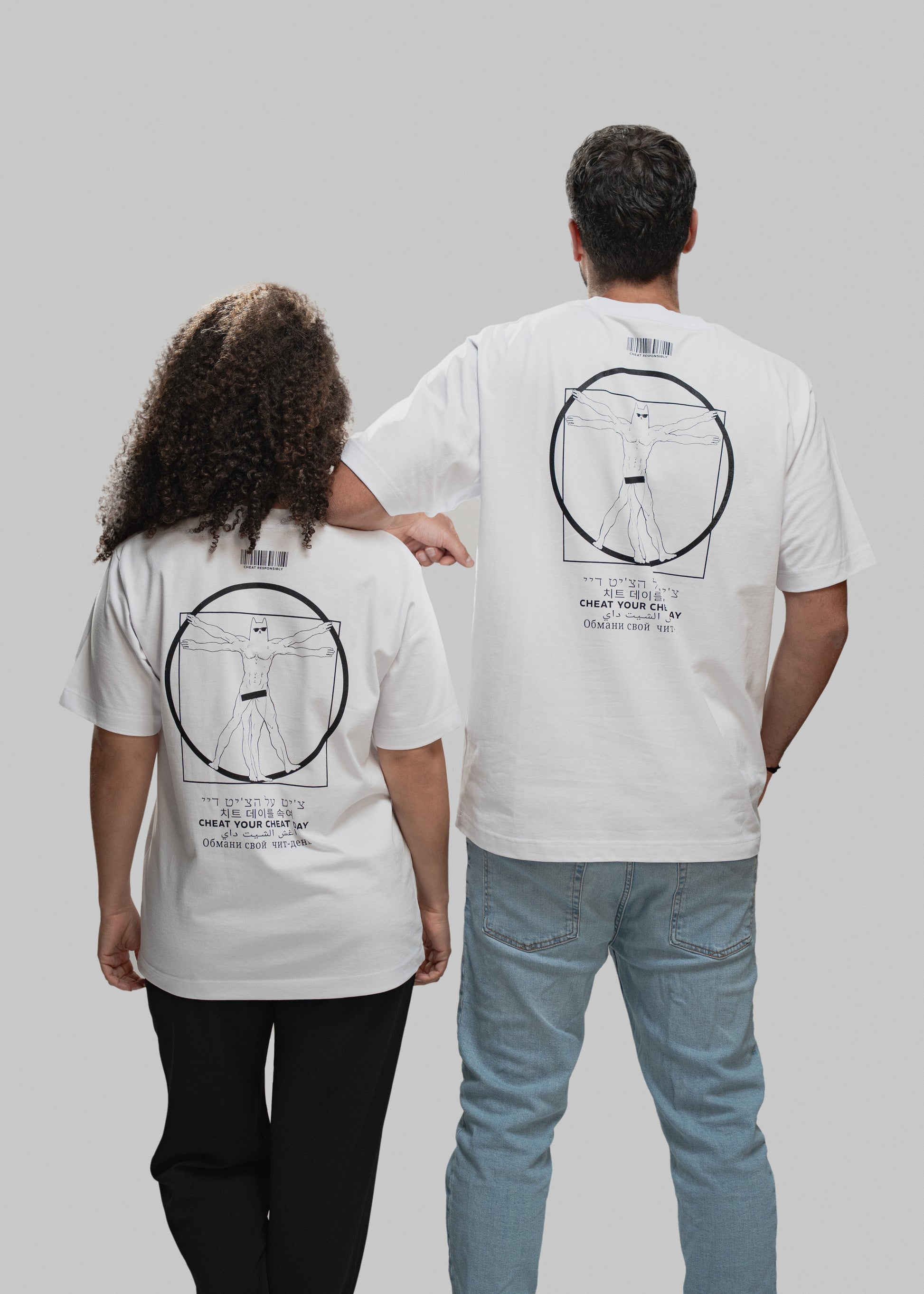 Das Bild zeigt zwei Personen von hinten vor grauem Hintergrund. Beide tragen weiße T-Shirts mit einem schwarzen, zentral platzierten Druck auf dem Rücken. Dieser zeigt eine an Leonardo da Vincis „Vitruvianischem Menschen“ angelehnte Figur mit Maske und Sixpack in einem Kreis und Quadrat. Unterhalb des Motivs steht der Claim „CHEAT YOUR CHEAT DAY“ in sechs verschiedenen Sprachen. Über dem Motiv befindet sich ein minimalistischer Barcode. Die linke Person trägt schwarze Hose und hat mittellanges, lockiges Haa