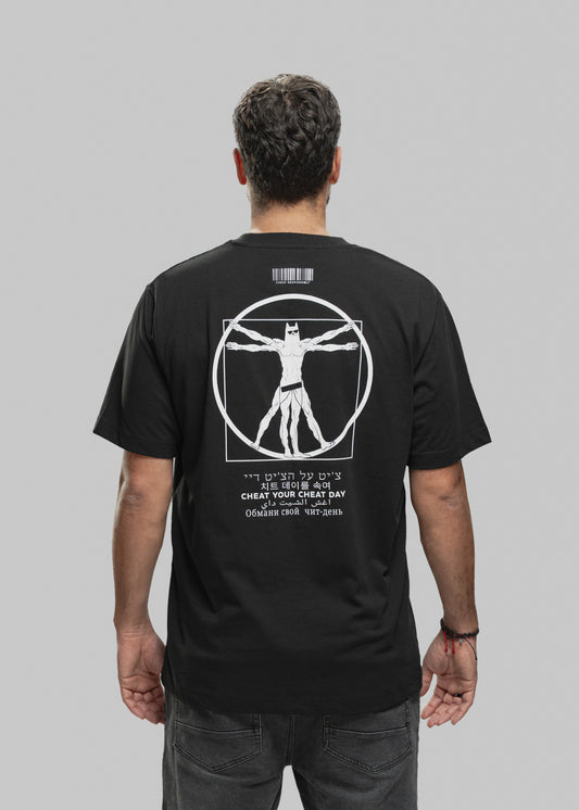 Ein Mann steht mit dem Rücken zur Kamera und trägt ein schwarzes T-Shirt mit einem auffälligen weißen Print auf der Rückseite. Im Zentrum des Designs befindet sich eine muskulöse Figur im Vitruvianischen-Stil – eine Mischung aus Da Vincis berühmtem „Vitruvianischen Menschen“ und einer Superhelden-Figur mit Maske, Sixpack und breiten Schultern. Die Figur steht in einem Kreis und Quadrat, beide Elemente sind weiß umrandet. Oberhalb der Grafik ist ein Barcode mit dem Schriftzug „CHEAT RESPONSIBLY“. Unterhalb d